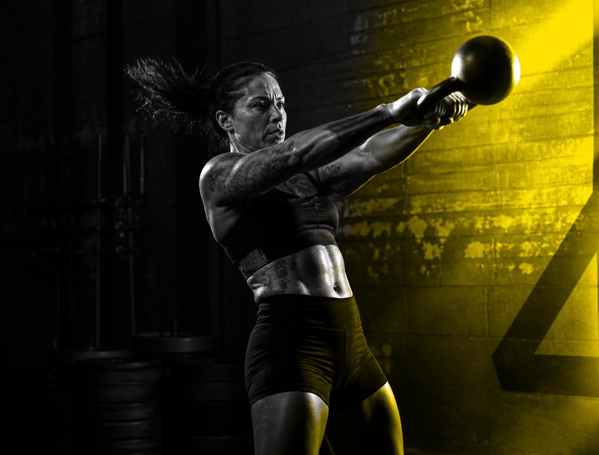Athlete training with a kettlebell in dramatic yellow light
